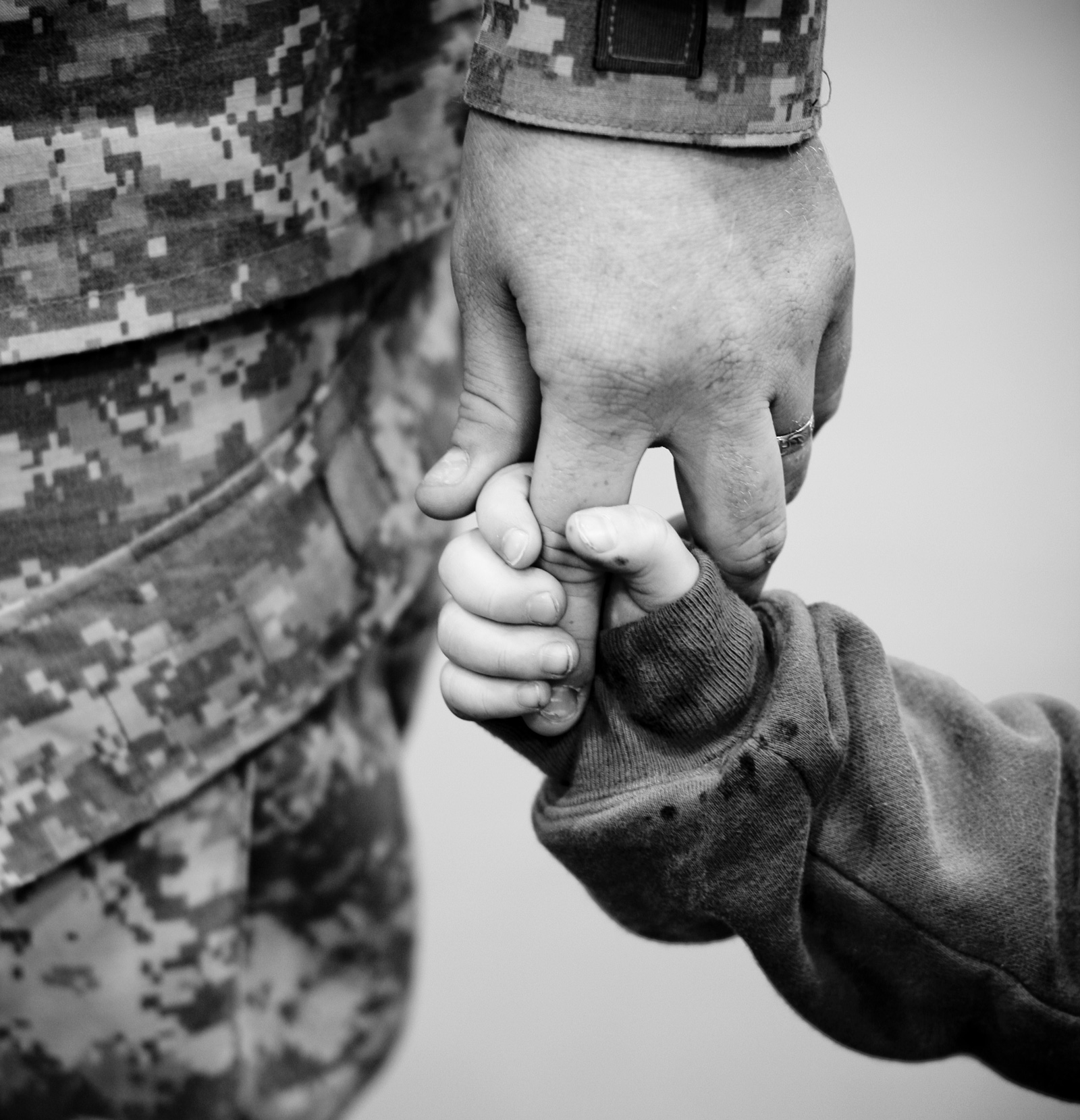 Small Child Holding Hands with a Soldier
